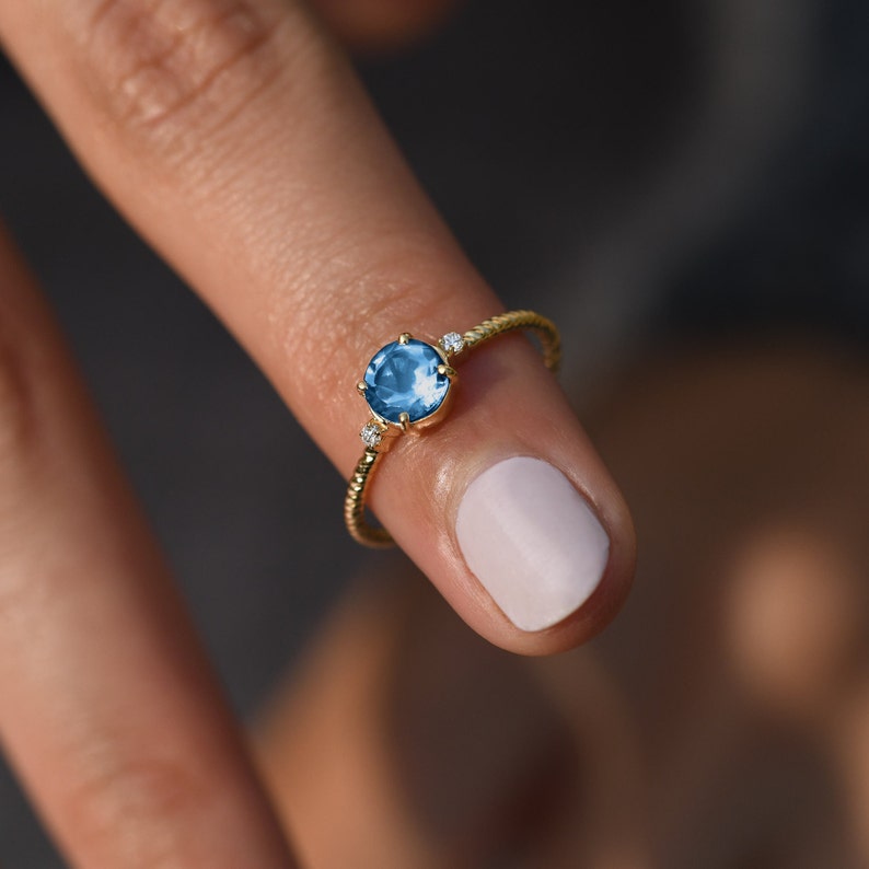 Deep blue gemstone ring in solid gold with diamond accents