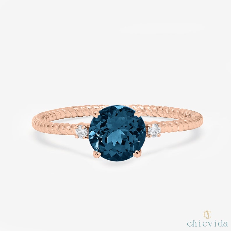 Blue topaz December birthstone ring in twisted gold setting