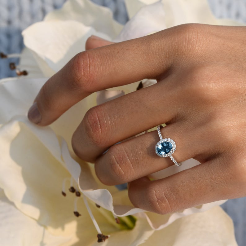 Blue gemstone ring with halo setting in fine gold jewelry style