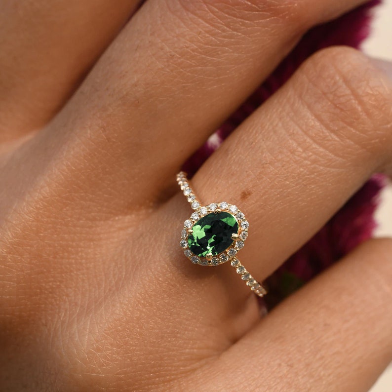 Halo gold ring with oval green gemstone and pavé diamond band